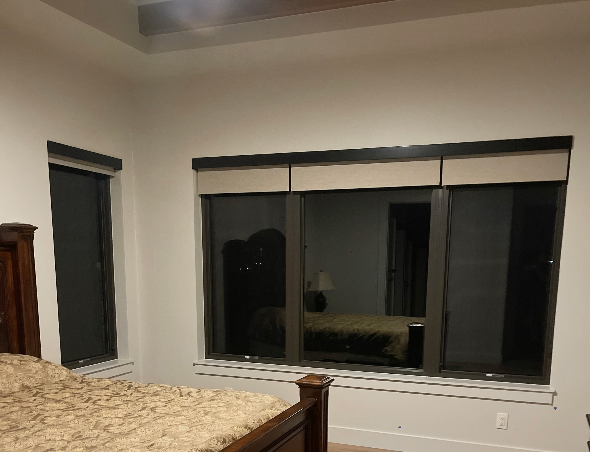 Light roller shades partially raised over bedroom windows